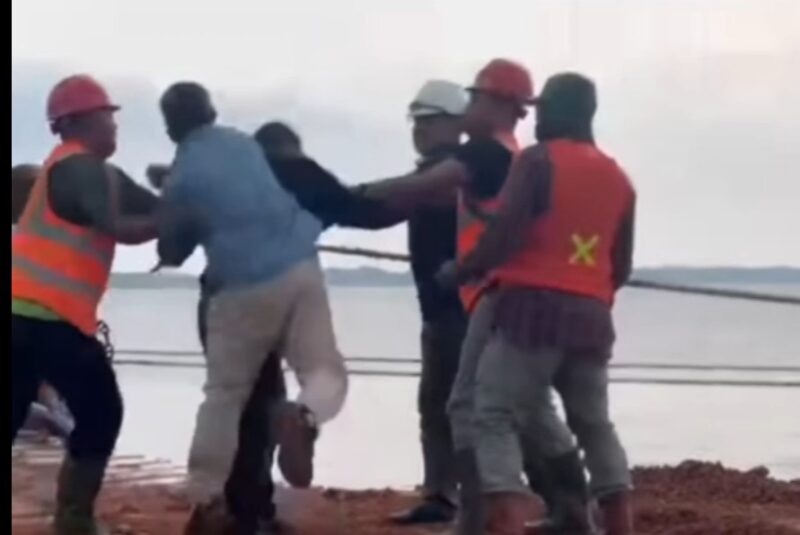 Seorang warga asli Kecamatan Singkep Barat berinisial NH menjadi korban pemukulan oleh oknum berbaju biru berinisial AC saat berupaya menghentikan aktivitas loading bauksit milik PT Hermina Jaya di Terminal Khusus TBJ, Desa Tanjung Irat, Kamis (1/5/2025). | f. Red