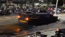 Tangkapan layar video Sebuah kendaraan taktis Brimob terekam kamera melaju kencang menerobos kerumunan massa aksi dan menabrak dua pengemudi ojek online (ojol). | f. Tangkapan Layar Video yang Beredar