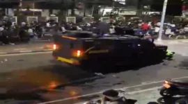 Tangkapan layar video Sebuah kendaraan taktis Brimob terekam kamera melaju kencang menerobos kerumunan massa aksi dan menabrak dua pengemudi ojek online (ojol). | f. Tangkapan Layar Video yang Beredar