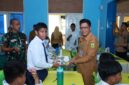 Salah satu siswa SMP N 01 Singkep berfoto bersama Kepala Dinas Kesehatan Kab. Lingga saat menerima Program Makan Bergizi Gratis dari Pemerintah | f. Red