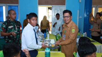 Salah satu siswa SMP N 01 Singkep berfoto bersama Kepala Dinas Kesehatan Kab. Lingga saat menerima Program Makan Bergizi Gratis dari Pemerintah | f. Red