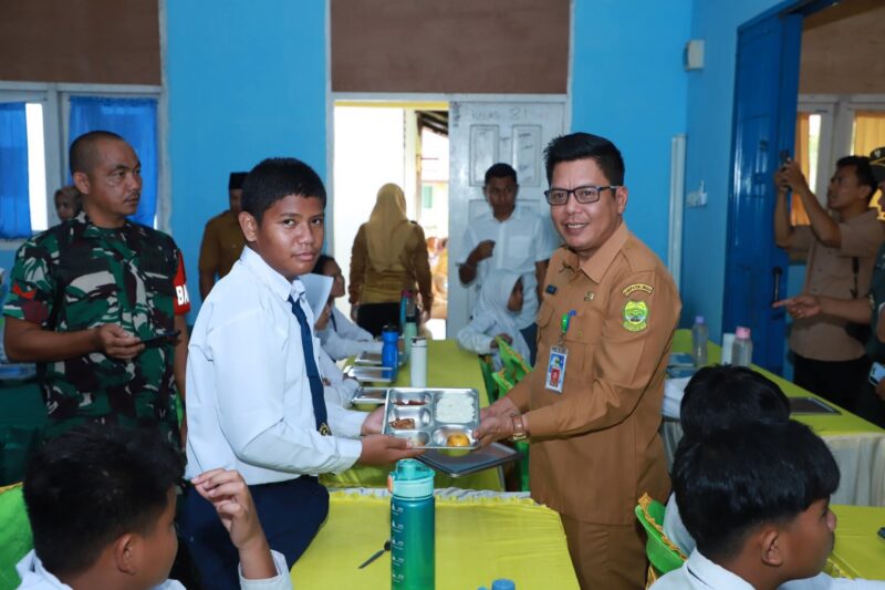 Salah satu siswa SMP N 01 Singkep berfoto bersama Kepala Dinas Kesehatan Kab. Lingga saat menerima Program Makan Bergizi Gratis dari Pemerintah | f. Red