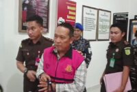 Salah satu tersangka kasus dugaan korupsi Jembatan Desa Marok Kecil saat digiring ke mobil tahanan oleh Kejari Lingga | f. Cahyo